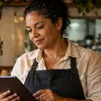 Dona de restaurante usando tablet no balcão